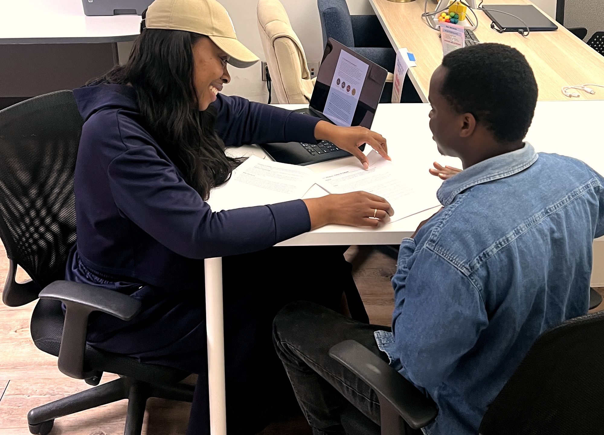 Keshia Lynch coaching a program staff member through a document at a work table